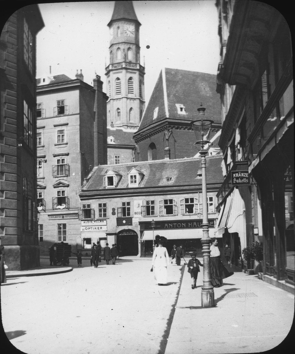 Skioptikonbild med motiv från gata i Wien med Michaeler Kirche i bakgrunden.
Bilden har förvarats i kartong märkt: Höstresan 1909. Wien 7. No: 7. Text på bild: "Die Michaeler Kirche".