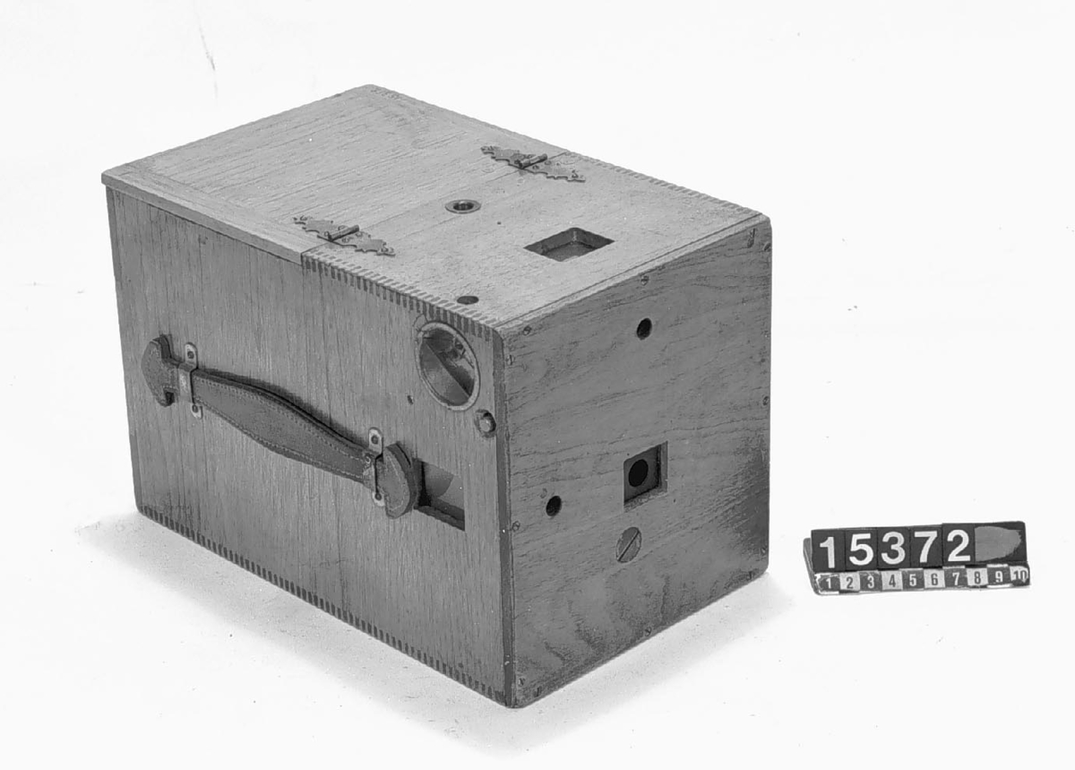 Bälgkamera i låda, för plåtar och rullfilm 10 x 13 cm, för film och plåtar. Kvalitetskamera. Skylt. "The Blair Camera Co, Boston, Patent 1887, 1890".
Tillbehör: Tygfodral, kamera, visirskiva, rullfilmskassett ("Eastman Kodak Dry plate & film Co, Rochester N.Y. U.S.A. Pat. 5.5 1885"), 2 st. dubbelkassetter 9 x 12, lucka och väska.