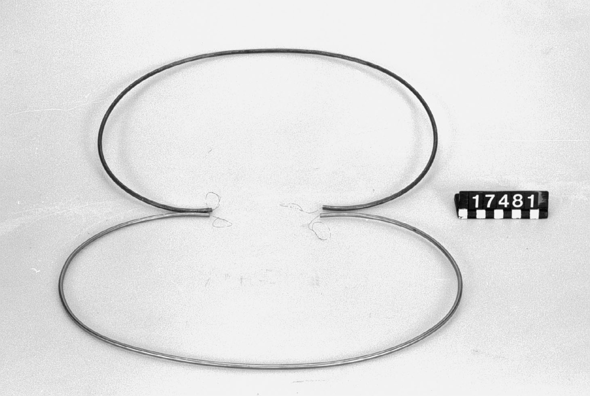 Två kapillärrör av stål. 0.5 mm invändig diameter. Yttre diameter: 5.0 resp 4.7 mm (det förra troligen oputsat, den senare putsat). Lagda i ring med 25 cm diameter.
