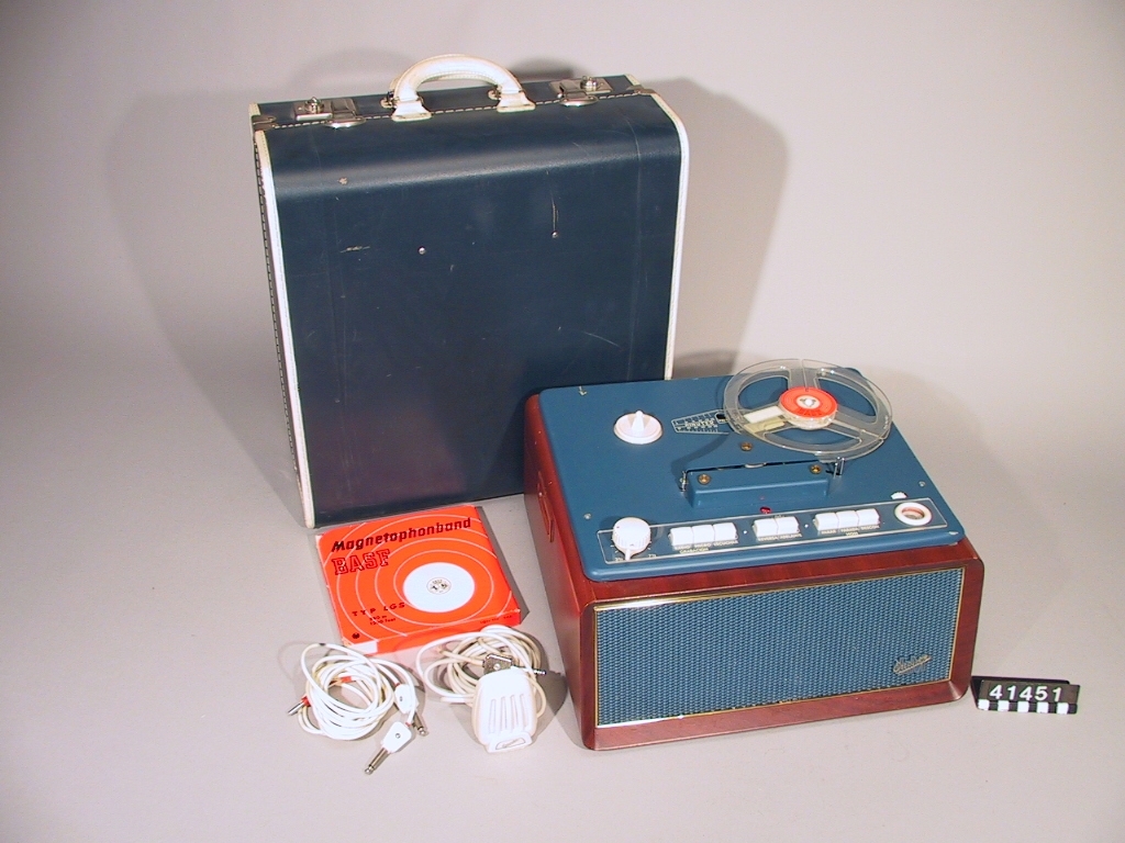 Tillbehör: Originalväska (av pressad papp), mikrofon, anslutningssladdar, magnetband (basf) och tomspole (basf).
