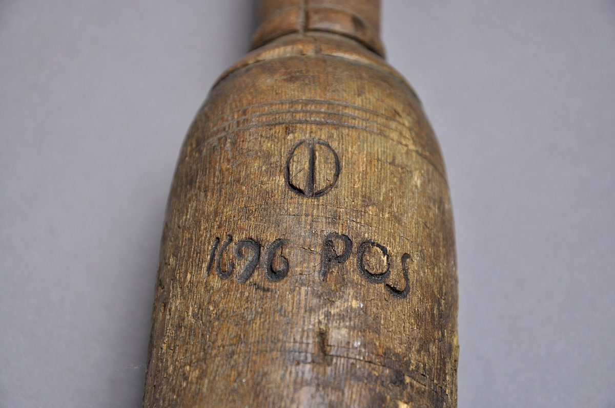 Besman av trä inristat med 1696 och signatur POS  med en metallbit i träklumpen i stället för bly. även ett bomärke finns på träklumpen komplett med metallkrok