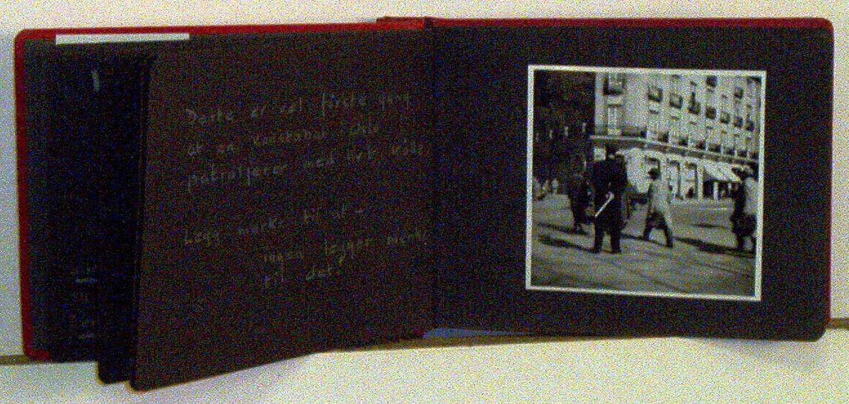 Fotoalbum med rød perm og sorte sider, med 11 bilder i sorthvitt.