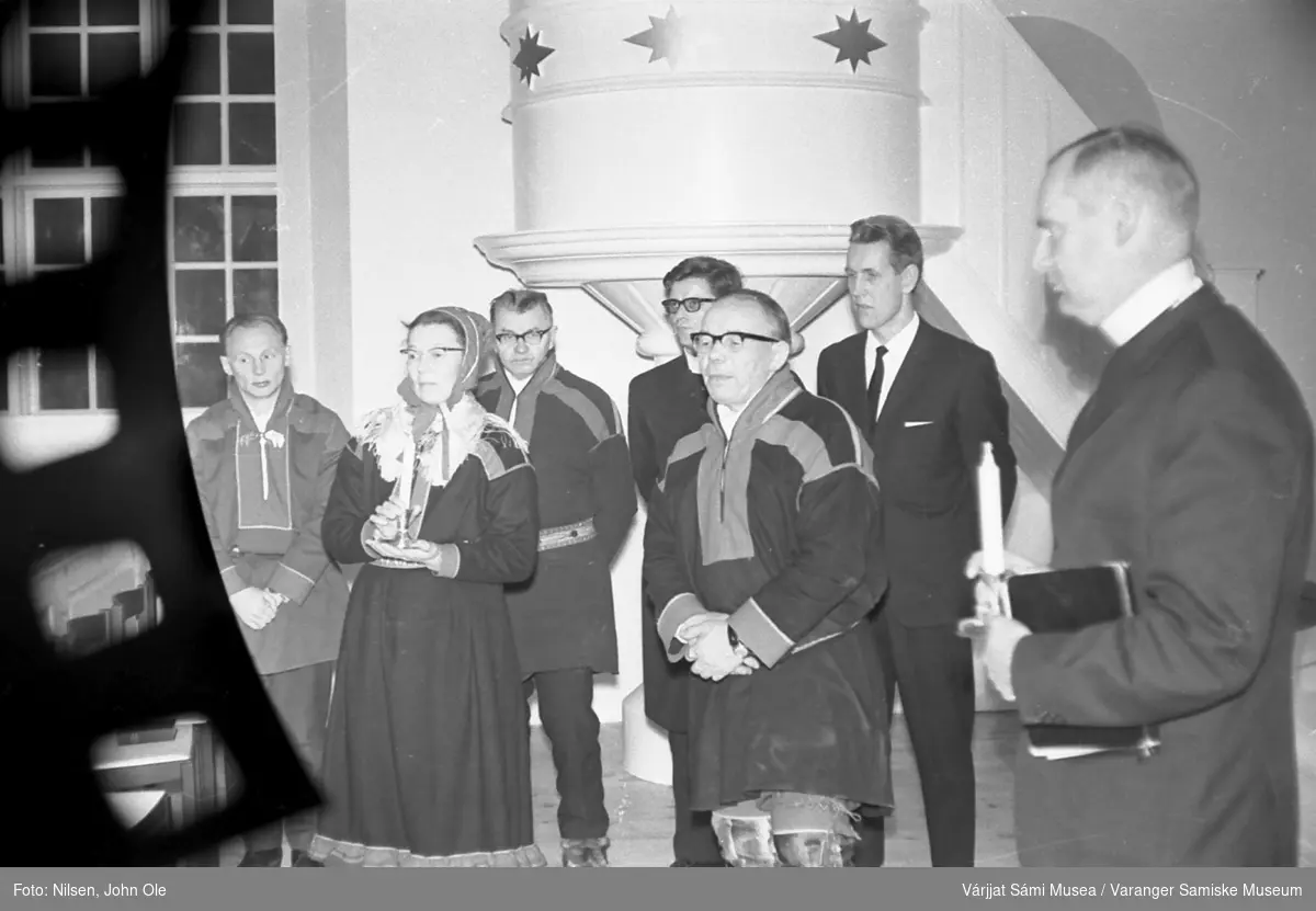 Gruppebilde inne i en kirke. Prekestol i bakgrunnen. Kvinnen med kofte og talgelys i hånden er Signe Nilsen, mens presten helt til høyre er Erik Schytte Blix. Ukjent sted høsten 1966.