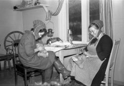 To kvinner sitter innendørs og syr skaller.  Nuvvus i  Finla