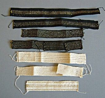Tjugotre stycken prover på vävda band i linne. Banden, i olika färger, mönster och bredder är vävda i rips. De flesta är band framtagna till kyrkliga textilier. Varp och inslag i oblekt, halvblekt och kulört lingarn och guld- eller silvertråd. 
WLHF-0366:1-14 med guld och/eller silvertrådar.
WLHF-0366:15-20 olika mönster och färger.366:17 är märkt med en etikett med texten: "Band Värmland vävt 82 1/2 öre + 10%", med provtrådar i oblekt, blått och rödbrunt under etiketten.WLHF-0366:21-23 halvblekta/oblekta, omönstrade, olika grovlek och bredd. Första bilden visar WLHF-0366:1-7. Andra bilden visar WLHF-0366:8-14. Tredje bilden visar WLHF-0366:15-23.