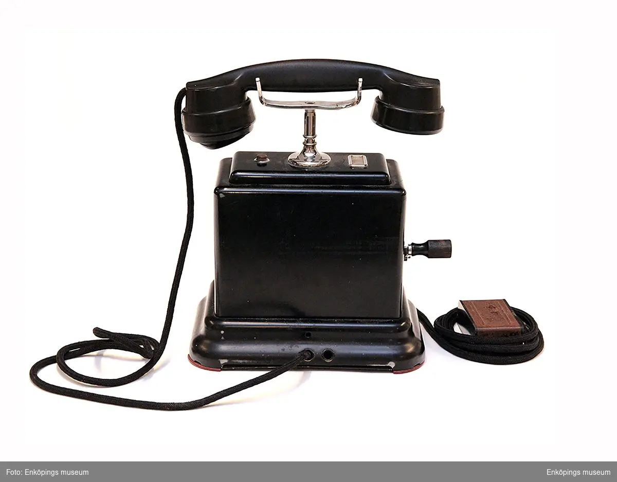 Vevtelefon med vev på ena sidan. På telefonens undersida är den märkt AB100 Schema A   K.T.V.1941.