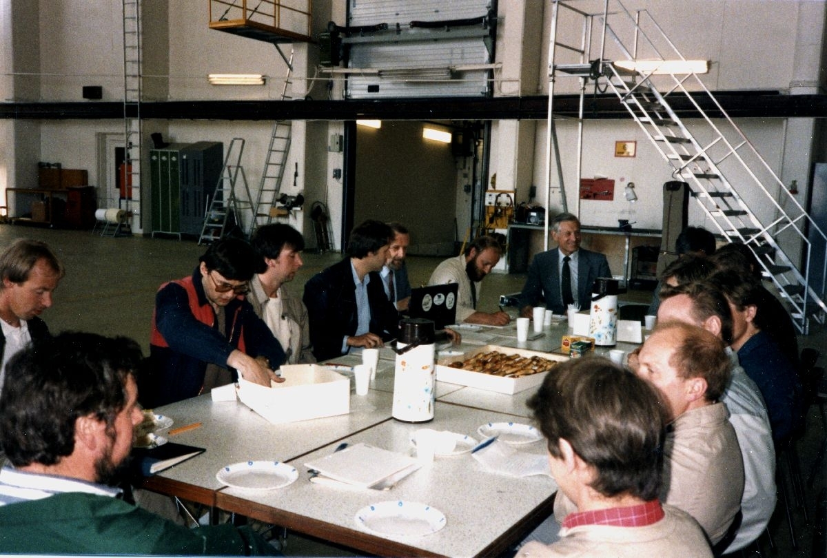 Lufthavn/Flyplass. Florø. En gruppe personer samlet rundt et bord i Widerøes hangaranlegg.