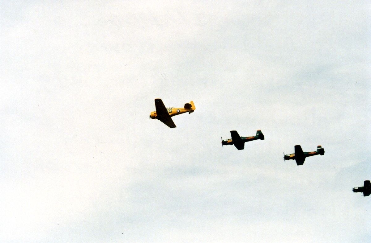 Fire fly i formasjon under et flystevne., T-6 Harvard og Yak-18.