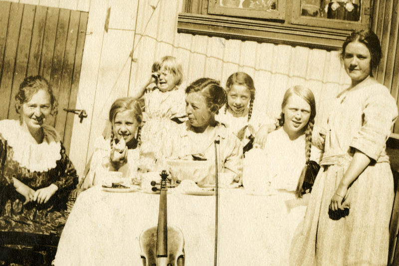 To damer og fem jenter i forskjellig alder oppstilt for fotografen.