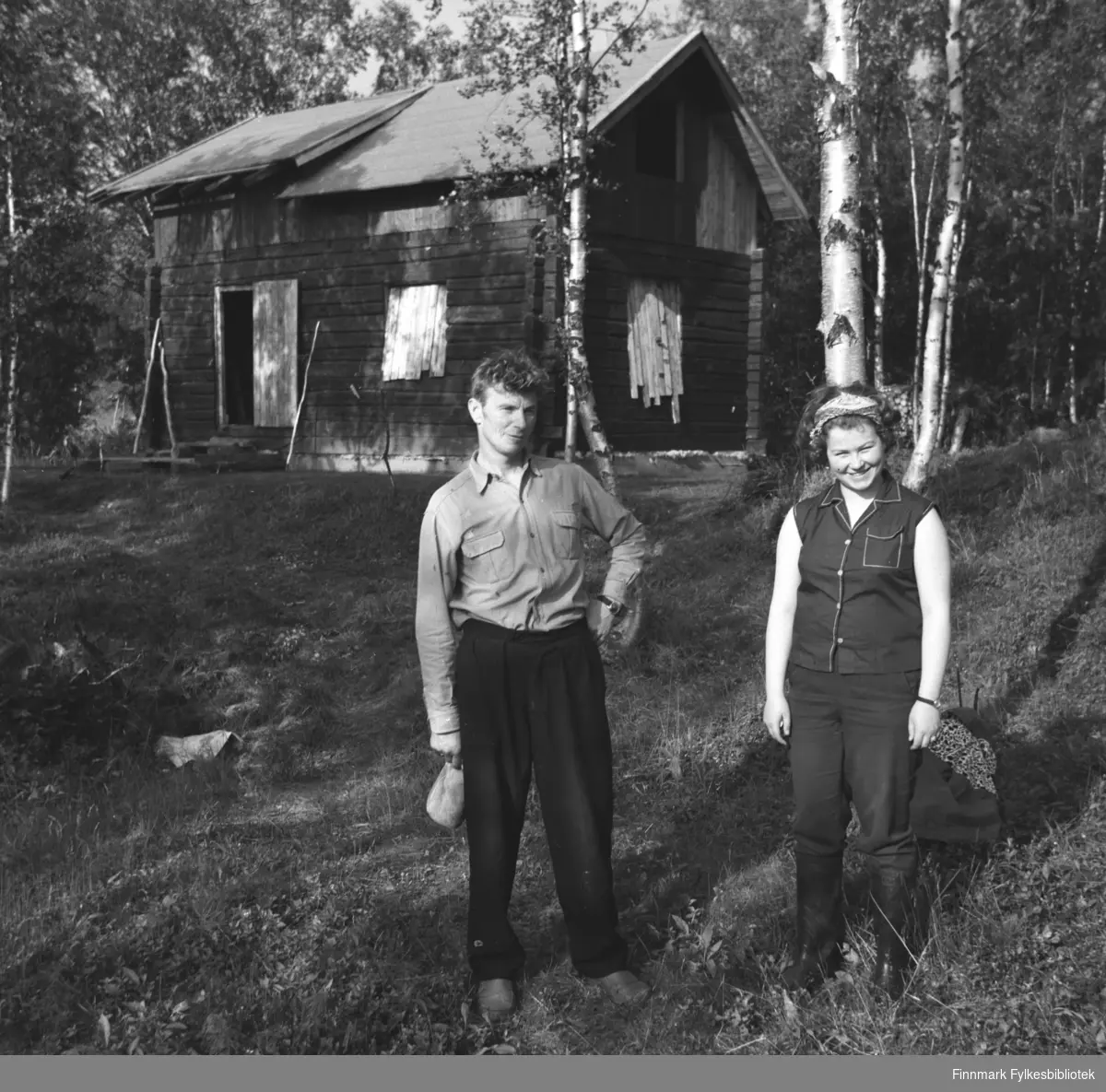 Eino Drannem og Turid Karikoski fotografert i skogen foran hytta i Neiden.