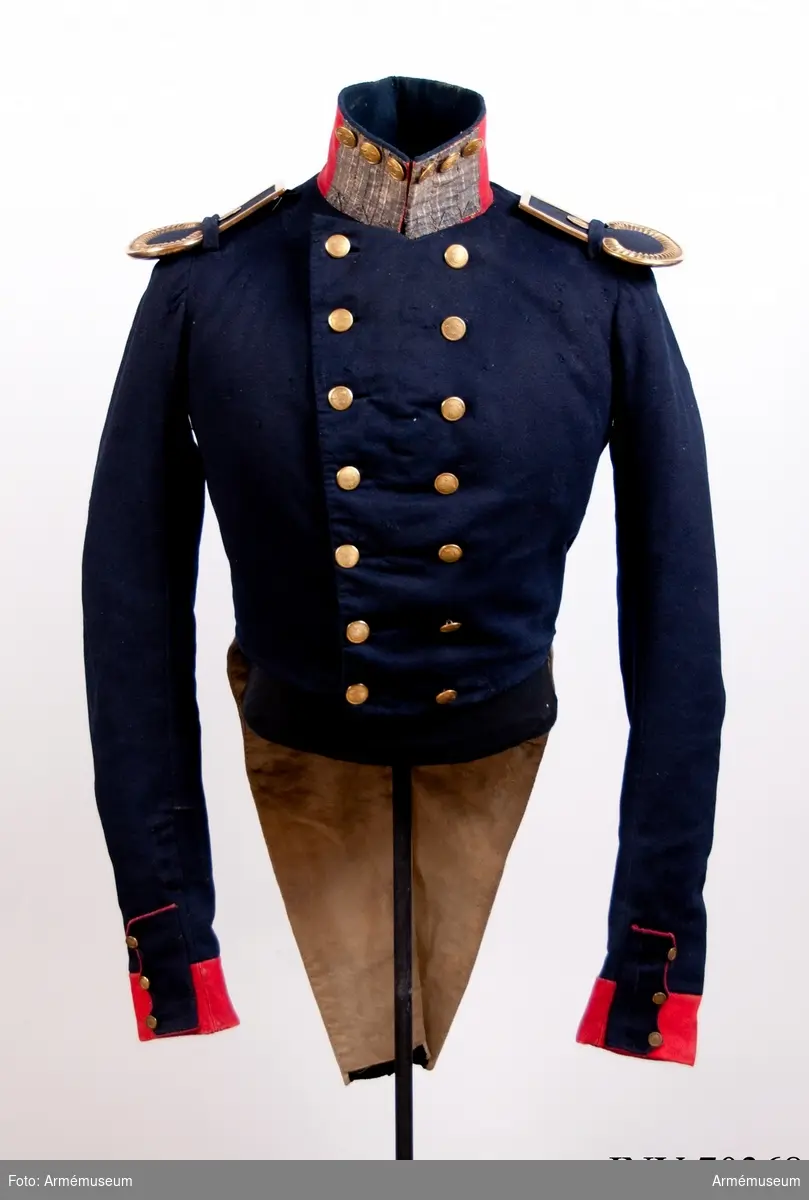 Grupp C: I.
Frack av mörkblått kläde med röd krage och ärmuppslag, med korprals och ordningsmans distinktion (primaries) på kragen.