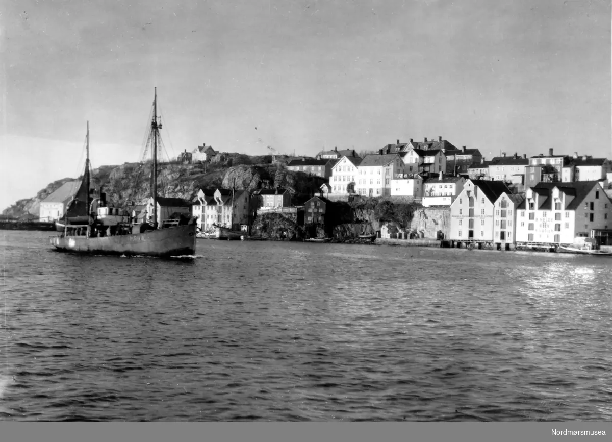 Bildet er fra havna i Kristiansund og viser M/S”Bjørnøy” M-84-A i fart inn Sørsundet.
Stålbåtens hoveddimensjoner er: L = 62 fot x B= 12,4 fot x D= 8 fot og byggeår er 1987 og utrustet med en BERGEN dieselmotor på 3300 hk, byggeår 1987. 
Eiere er Bernt Skarbøvik  A/S, Ålesund. I bakgrunnen ses Kirklandet med Jemar Norpowerbrygga bak fiskebåten. Info: Peter Storvik. - 
Båt i Sørsundet på vei inn til Kristiansund.
I bakgrunnen ser vi bryggene i Håla og Sørholmen på Kirkelandet.  Oppe til venstre ser vi noe av bebyggelsen  på Hålahaugen og sykehuset i Frueenget som var ferdig i 1899. 
I bakgrunnen ses Kirklandet med Jemar Norpowerbrygga bak fiskebåten
Nordmøre museums fotosamling