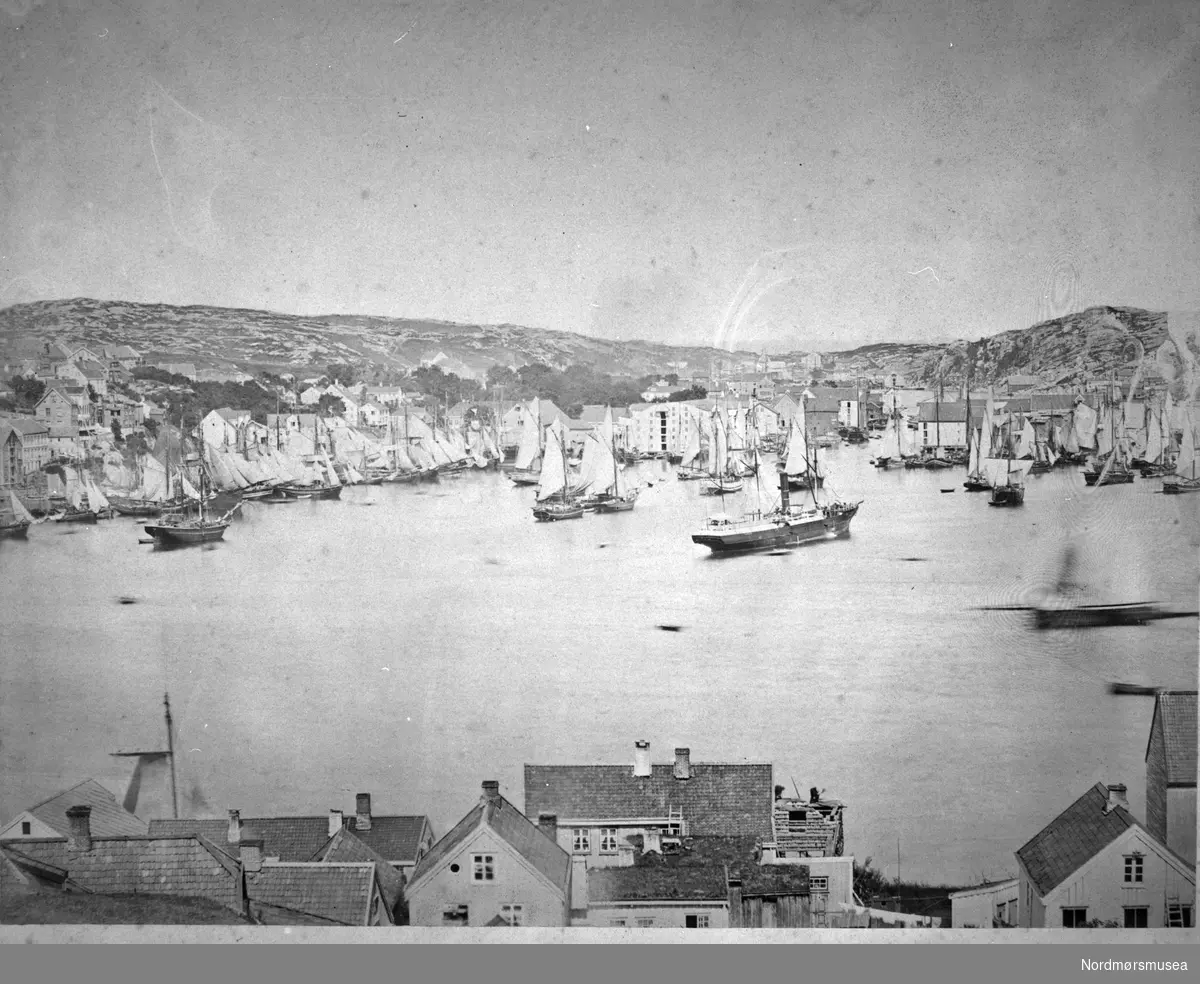 Foto fra tatt fra Sagerbukta på Innlandet mot havnebassenget og Kirkelandet i Kristiansund på andre siden av havna. Bildet er trolig fra perioden rundt 1880 til 1890. Sundbåt. Fotograf er Johan K. Engvig. Fra Nordmøre Museums fotosamlinger.
