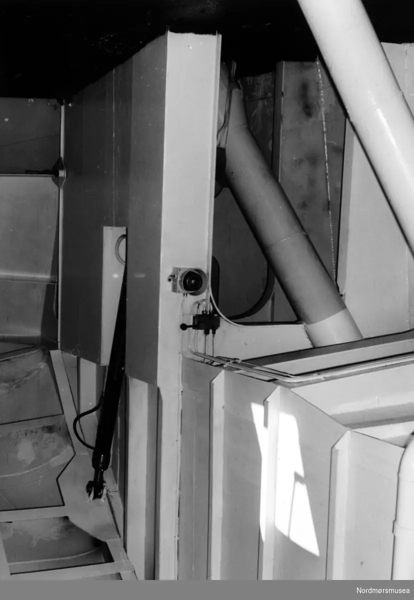 Et foto av de hydrauliske systemet til å løfte baugen på ei ferge, sett fra bildekket. Fergen er muligens ferga Gildeskål, og baugen er her på bildet nede. Fra Nordmøre Museums fotosamlinger.

