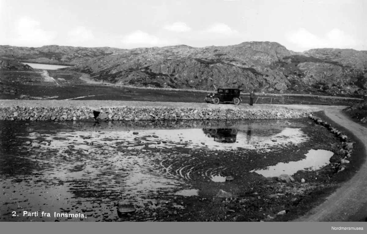 Parti fra inn-Smøla, hvor vi ser en bil og en mann stående langs en ...