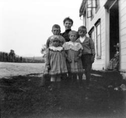 Foto av en kvinne, her sammen med fire små barn utenfor et b