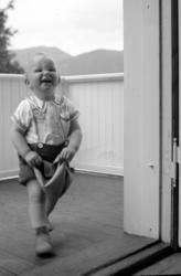Foto av en liten gutt på en veranda. Gutten er Per Georg Sve