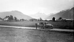 En mann poserer foran en bil. Fra Nordmøre museums fotosamli