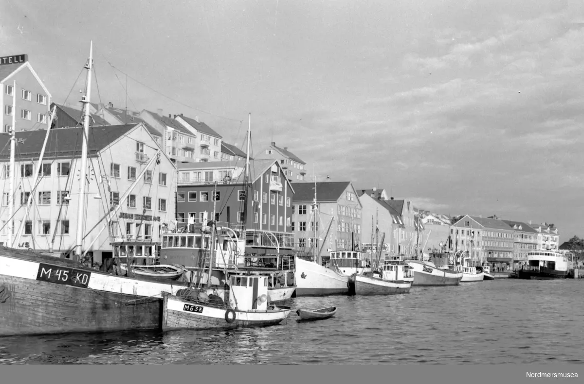 Foto fra Vågeveien/Vågekaia på Kirkelandet i Kristiansund, med fiskebåtene på rad og rekke langs havna. Fra Nils
Williams fotoarkiver. Fra Nordmøre museums fotosamlinger.

