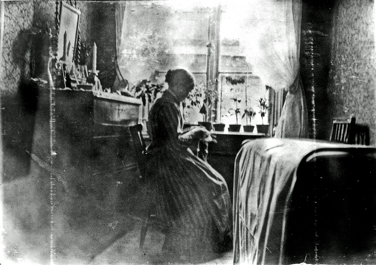 En kvinna som sitter och handarbetar. Fotograf Alfred Bergendahl. Givare H Bergendahl.