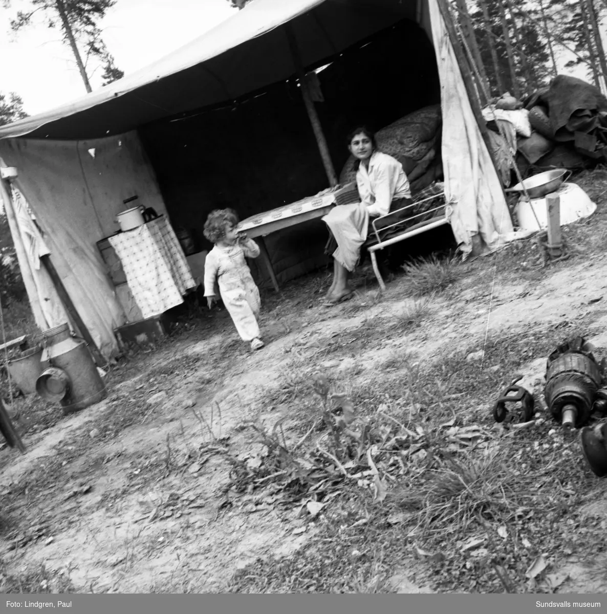 Familjen Fardi och Roza Taikon med barn och barnbarn samt andra släktingar på en tillfällig okänd lägerplats (Sundsvall- eller Timråområdet). Familjen tjänar sin utkomst från skrothantering och metallåtervinning.
