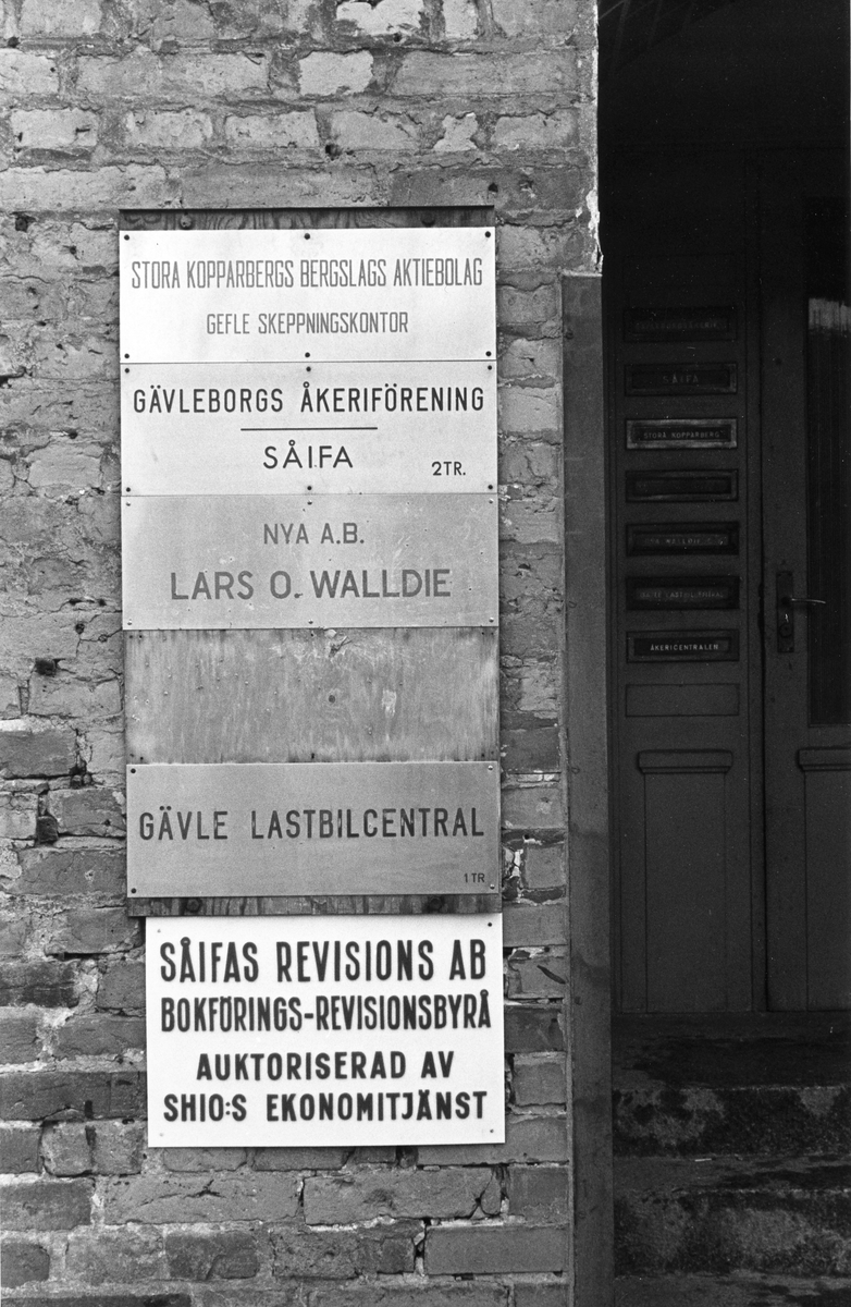 Namnskyltar med bland annat. Gefle Skeppningskontor; Gävle Lastbilscentral; Nya A.B. Lars O. Walldie; SÅIFA med mera.
Från utställningen "Gävlar i stan" på Gävle Museum 1967.