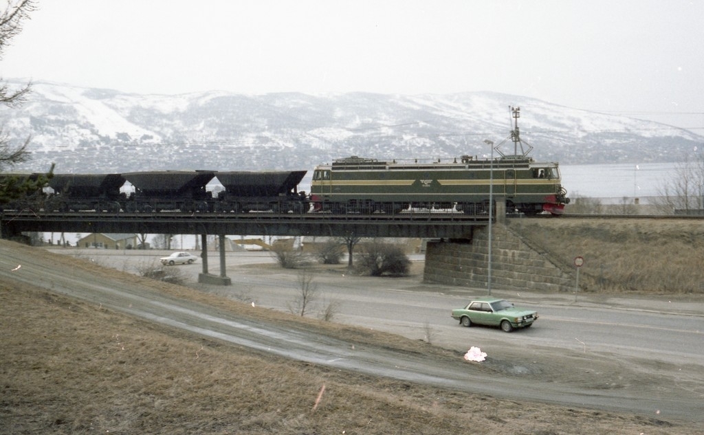 Malmvogner lastet med olivin skiftes fra Narvik Havn, Fagerneskaia og opp til Narvik stasjon og videre til Øvre Rangerstasjon.  Skiftet  trukket av et elektrisk lokomotiv av type El. 15, Skiftet passerer over brua over Sjøbakken i Narvik.