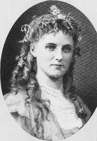 Christina Nilsson i oval ram. Hon bär klänning och har blommor i håret.

Jfr rollporträttet som Ofelia i Hamlet. (AB).