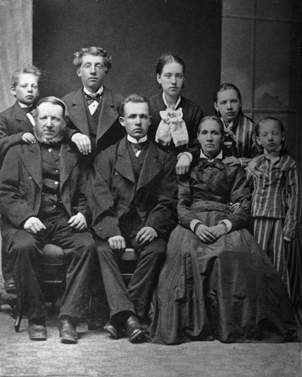 En familj med sex barn hos fotografen.
Helfigur, ateljéfoto.