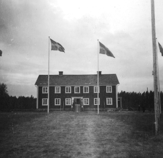 Foto på huset med två flaggstänger utanför.