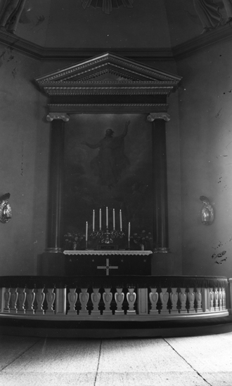Foto på en altarmålning med en altarrundel och altarborf med ljusstake på.