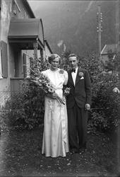 Brudepar utenfor hus.