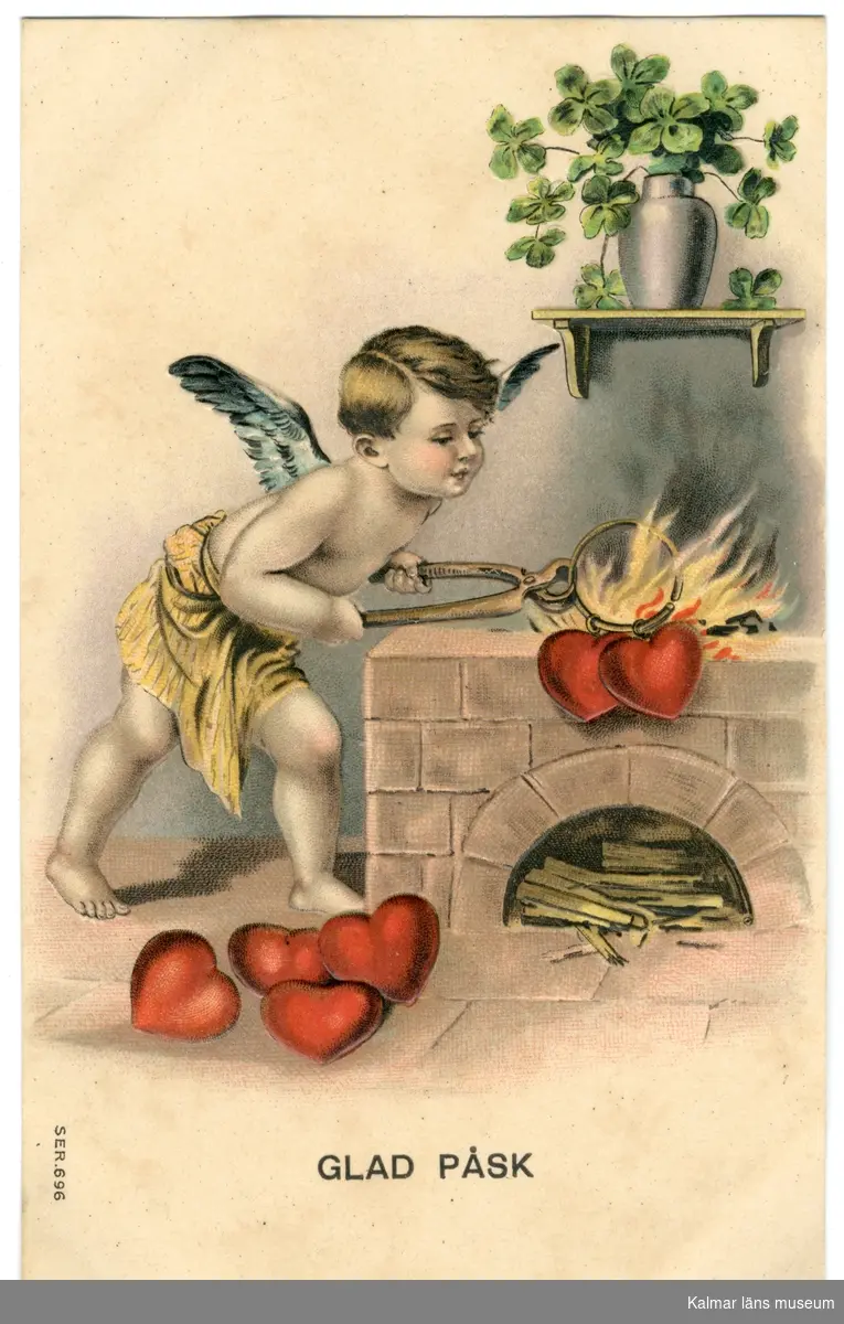 En pojke med blågröna änglavingar och ett gult tygskynke runt underkroppen står vid en spis där det brinner en eld ovanpå. Han håller i en tång med båda händerna, i tången sitter en ring med två röda hjärtan. På golvet ligger ytterligare fyra hjärtan. På  en hylla ovanför spisen sitter en hylla på väggen, på hyllan står en vas med fyrklöver.