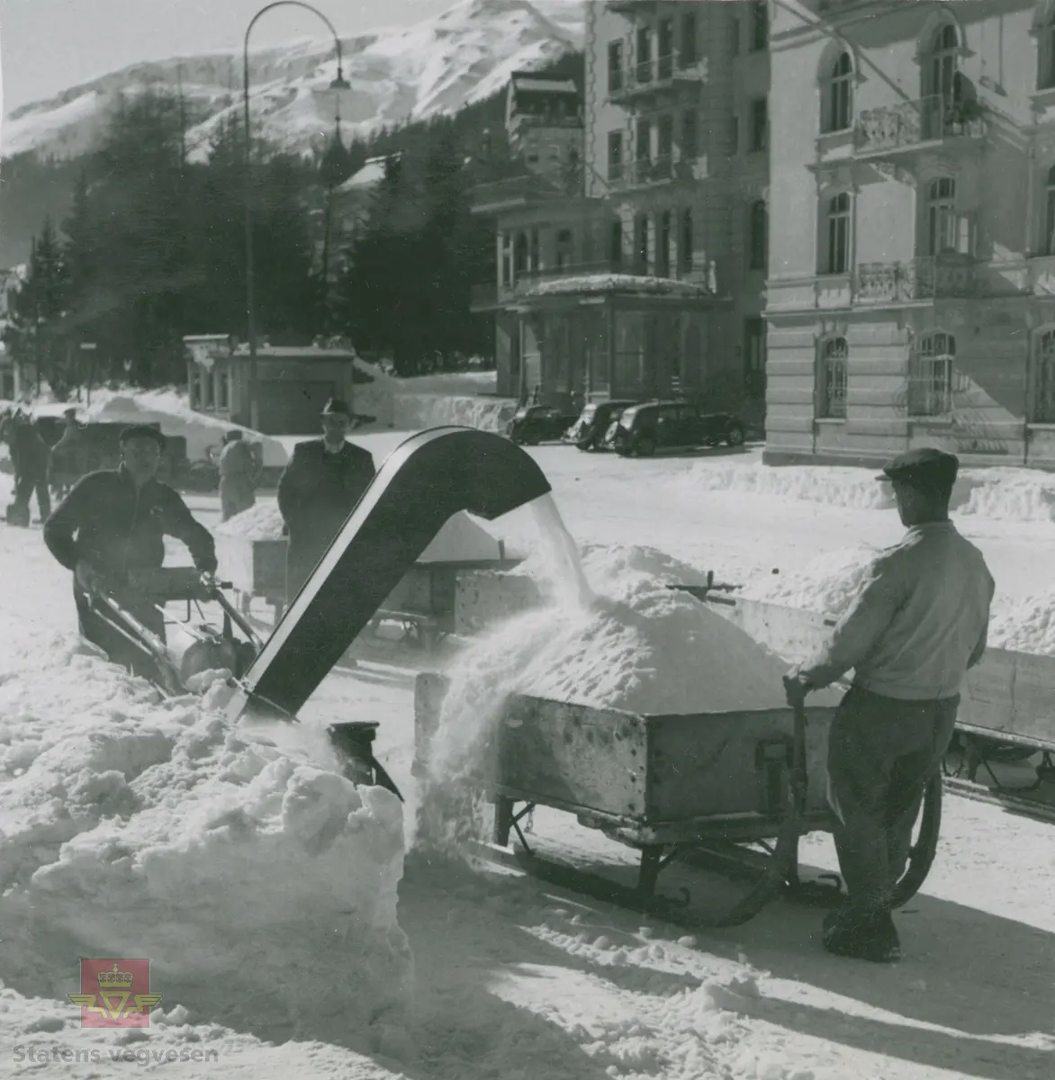 Demonstrasjon av Rolba Snow-Boy 2003 snøfreser. Snøfresing og rydding av snø i gatene i Davos i Sveits 1949. Snøen ble samlet opp på en slede og fraktet bort med håndkraft.