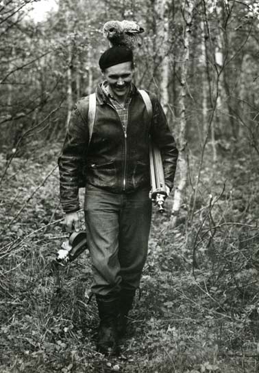 Hilding i skogen med stativ och kamera juli 1958. På huvudet sitter en uggleunge.