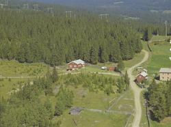 Privathus. Rødt enetasjes hus, rødt uthus. Vei til venstre p