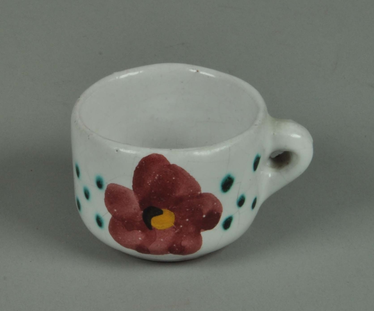 Keramikkopp med hvit glasur og påmalt blomstermotiv.