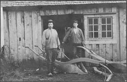 Smed Ola Heggvik og hjelpesmann Meier Eide med to ploger.