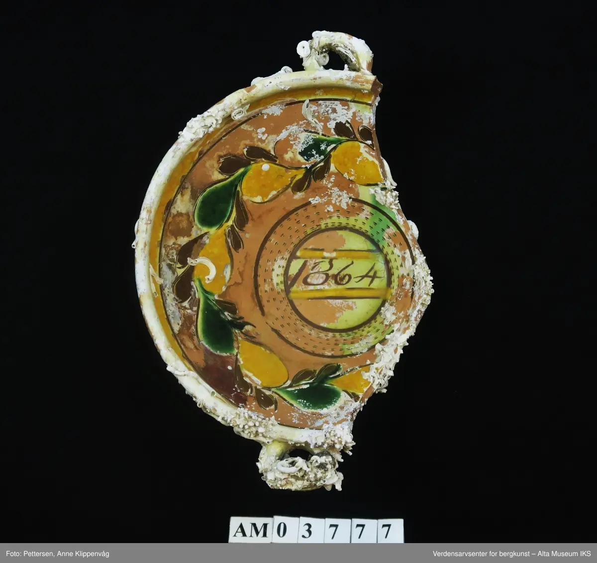 Rester av rur, mest på yttersiden av skålen. Del av en skål, med rester etter glasering.