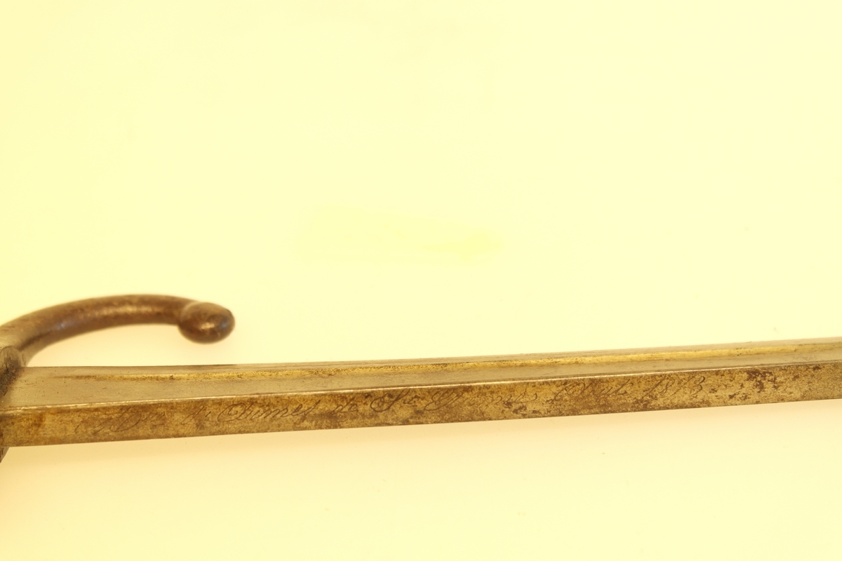 Bajonett (a) med slire (b). 
a) Støpt stål, smidd jern, messing. Stålklinge. Stopper av jern. Messinghåndtak med spor for geværet.
b) Jern.