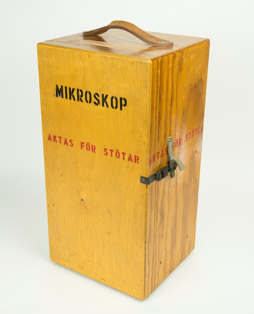 Mikroskop med trensformator. Mkroskpet är placerat i trälåda.