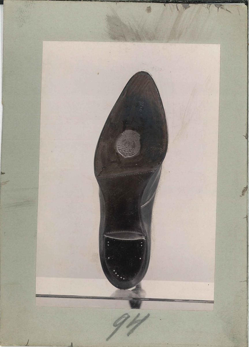 Fotografi av ett skodon. Sko. Bild på undersidan av skon.

Använd som reklam på A F Carlssons skofabrik.

Ingår i en samling med 123 stycken kort i kartong.