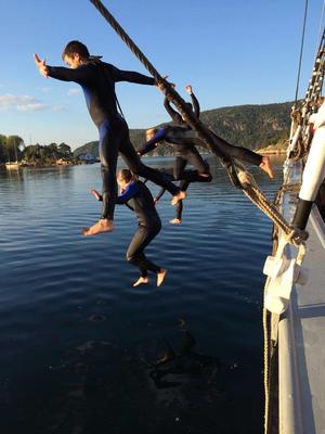 Fire ungdommer i svømmedrakt hopper i vannet fra skonnerten "Svanen".. Foto/Photo