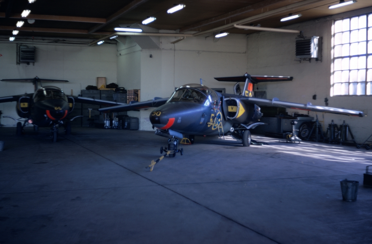 Flygplan SK 60 nummer 50 och 66 tillhörande F 5 Krigsflygskolan, står i en hangar på F 3 Malmen, våren 1973.