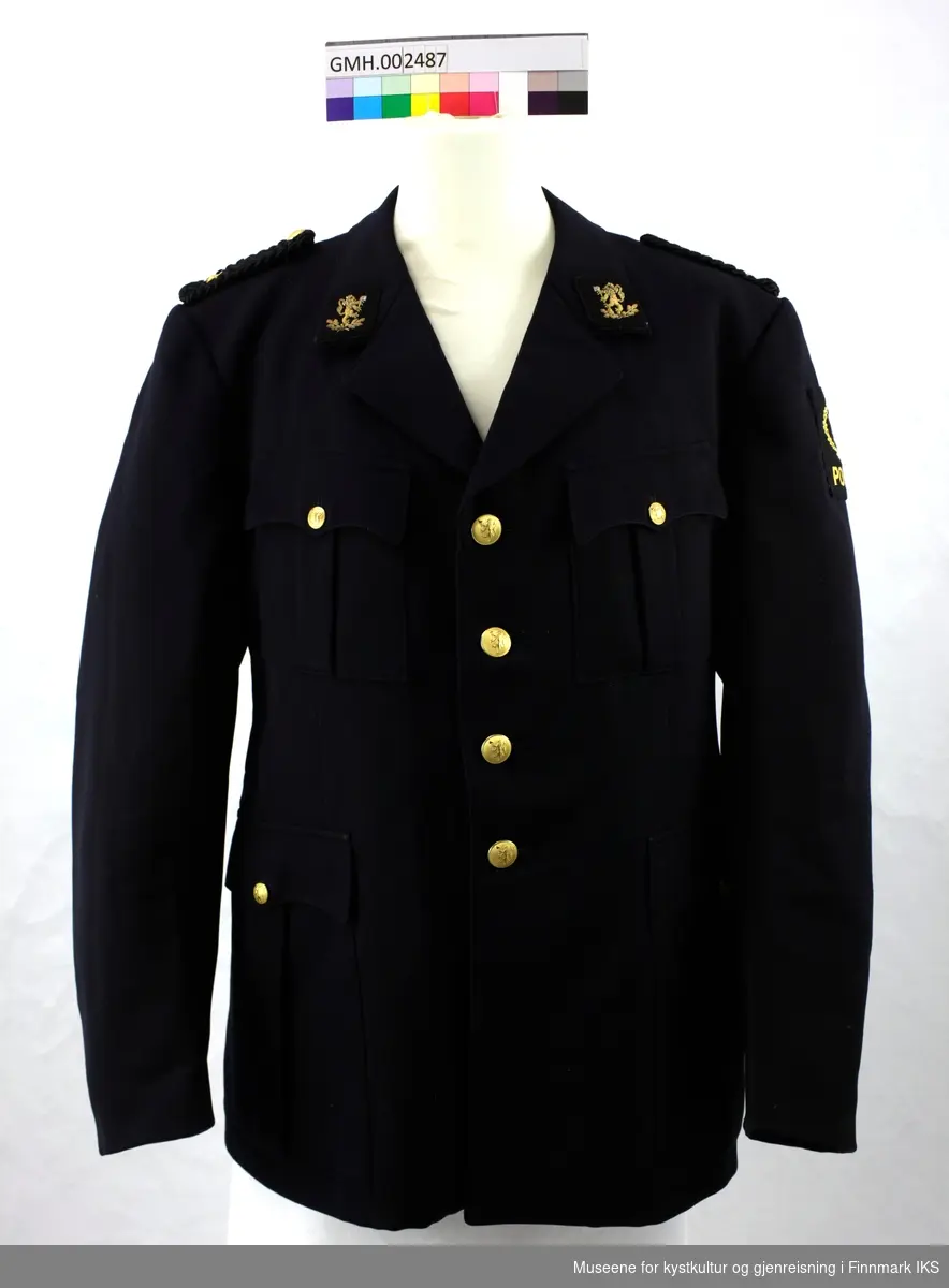 Svart uniformsjakke med fire gyllne knapper, To lommer på hver side som lukkes med knapp samt epoletter med distinksjon med gyllen stjerne. To knapper bak.