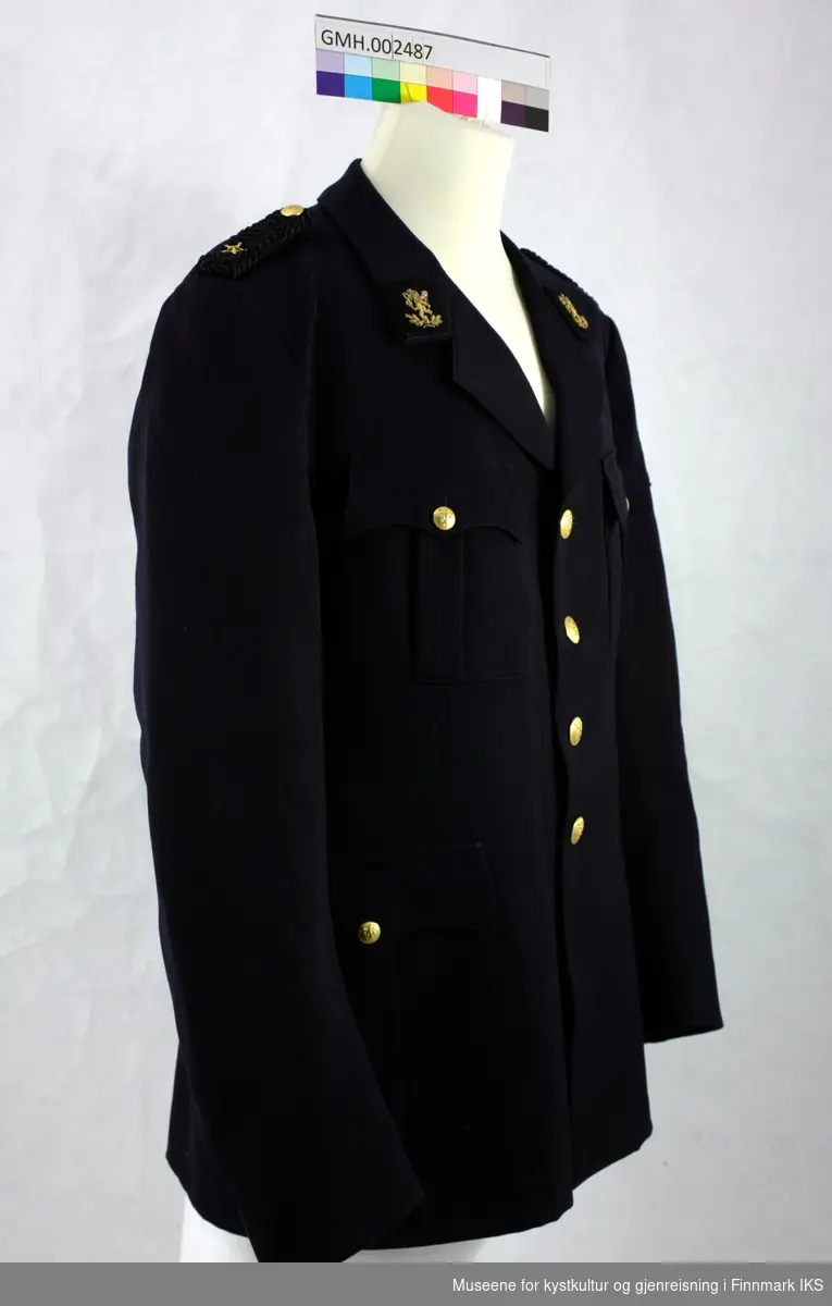 Svart uniformsjakke med fire gyllne knapper, To lommer på hver side som lukkes med knapp samt epoletter med distinksjon med gyllen stjerne. To knapper bak.