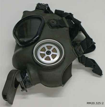Skyddsmask av grönt gummi bestående av ansiktsskydd med ögonglas och bandställ.