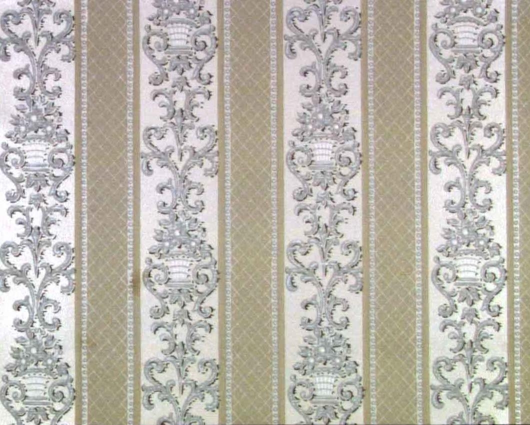 Ett lodrätt randmönster med två varierande bandmotiv. Dekoren består bla av blomsterkorgar, franska liljan dekor, broskornament  och lodrätta pärlstavar. Tryck i vitt, satinerat vitt, ljusgrått och beige.