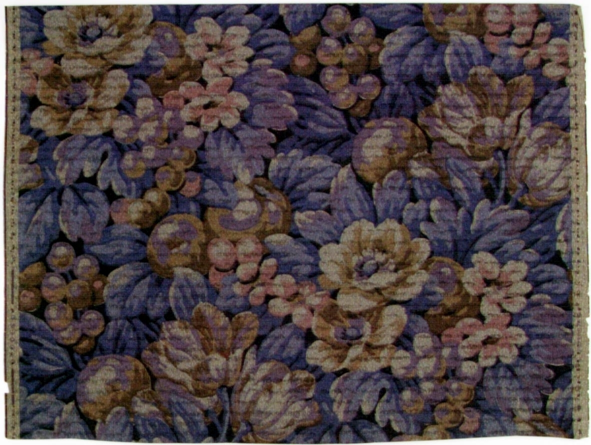 Tätt ytfyllande blommönster i flera bruna, blå och ljuslila nyanser på ett grått genomfärgat papper. Övertryck med streckmönster.