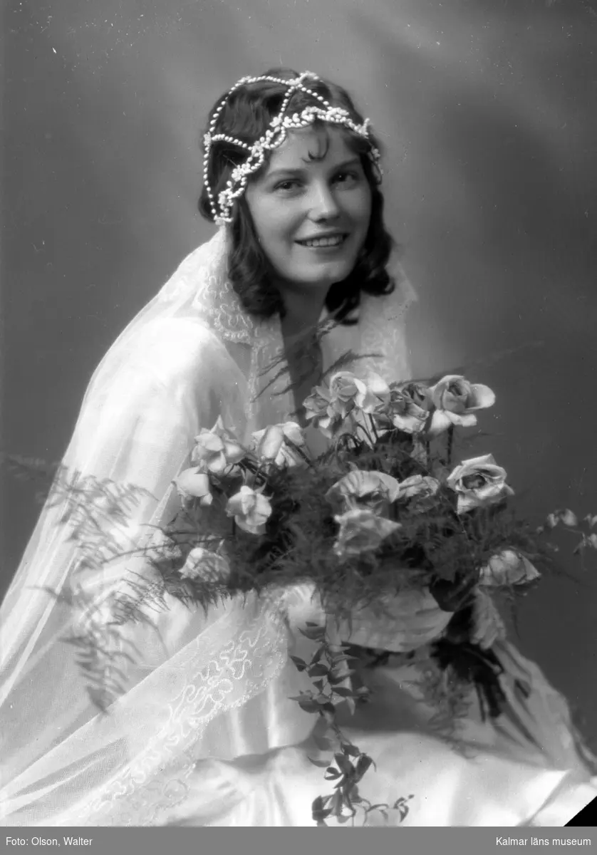 Porträtt på en brud med brudklänning och brudbukett.